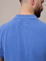 Remera polo celeste de piqué de algodón, corte clásico, con cuello y mangas acanalados.