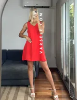 Vestido corto color coral, con escote en V delantero y trasero, sin mangas, con bolsillos laterales y forro en el busto.