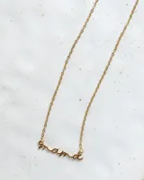 Collar dorado con dije de la palabra 'mamá' en letra cursiva, con cadena de eslabones finos.