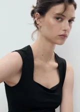 Top sin mangas color negro, de tejido elástico y diseño entallado, con escote cuadrado y tirantes anchos.
