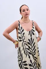 Vestido largo color crudo con estampado de hojas negras, de corte suelto y breteles finos.