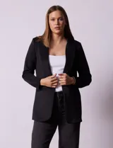 Blazer color beige, entallado, con cuello con solapa, abertura central con botón y bolsillos delanteros.