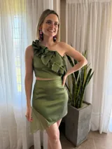Conjunto de falda y top de un hombro color verde pistacho. El top tiene tableado y la falda tiene un aplique en gasa sobre uno de los costados que genera un vuelo asimétrico.