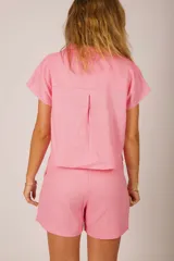 Camisa corta color rosado, de corte holgado y mangas cortas.