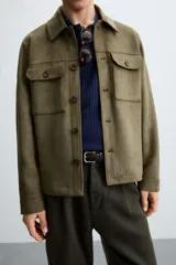 Sobrecamisa color beige de tejido efecto ante, corte regular fit, con cuello solapa, manga larga con puños abotonados, bolsillos de parche con solapa en el pecho y bolsillos de ojal en la cadera.