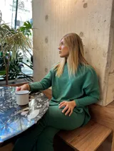 Conjunto de sweater y pantalón verde acanalado de corte suelto. El sweater tiene tajos a los costados.