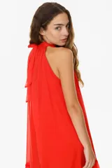 Vestido largo blanco de algodón con cuello halter y falda escalonada con volados.