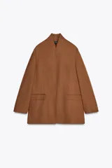 Blazer color marrón de cuello mao confeccionada en hilatura con mezcla de lino. Manga larga acabada en abertura y botones. Bolsillos con solapa en delantero.
