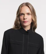 Campera bomber negra de viscosa con cierre delantero, bolsillos con solapa y pespuntes contrastantes en color blanco.