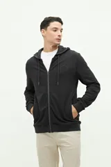 Campera verde militar de felpa con capucha ajustable y cierre frontal. Tiene un pequeño logo estampado en el pecho.
