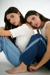 Pantalón de jean azul con corte acampanado y diseño de bloques de color en diferentes tonos de azul.