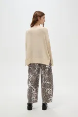 Sweater holgado de poliéster y lurex, color beige, con cuello redondo y manga larga.