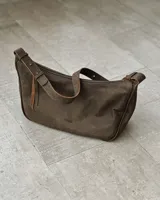 Cartera bandolera marrón de cuero con correa ajustable.