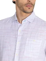 Camisa de manga corta blanca con textura multicolor, confeccionada en lino orgánico y tencel. Tiene bolsillo en el pecho con botón.