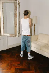 Bermuda baggy de jean celeste con lavado gastado en los laterales y bordados de letras chinas en negro y blanco.