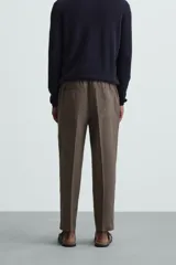Pantalón negro de lino, corte recto y relaxed fit, con cintura elástica ajustable con cordón, bolsillos laterales y traseros.