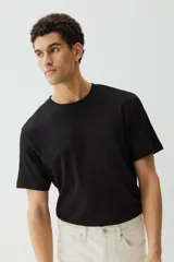 Remera negra de punto texturizado, corte regular, cuello redondo y mangas cortas.