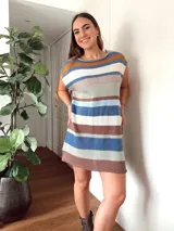 Vestido corto tejido con hilo de algodón a rayas horizontales en tonos celeste, azul, marrón, blanco, naranja y verde. Tiene cuello redondo y mangas cortas. El ruedo es desflecado.