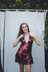 Vestido corto con lentejuelas color verde esmeralda, escote en V profundo y espalda descubierta.