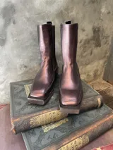 Bota de caña media color cobre, con elásticos laterales y suela cuadrada.