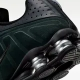 Zapatilla deportiva Nike Shox R4, color negro y verde oscuro (seaweed), con detalles plateados en el sistema de amortiguación Shox. Presenta una capellada de cuero sintético y malla con el logo Swoosh en el lateral.