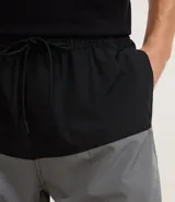 Bermuda de baño masculina confeccionada en microfibra, con cintura elástica, cordón ajustable, bolsillos laterales y trasero con cremallera, y estampado bicolor.