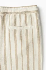 Short de algodón a rayas verticales color beige y marrón claro, con cintura elástica ajustable con cordón, bolsillos laterales y bolsillo trasero.