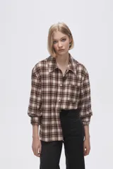Camisa a cuadros marrón y beige de manga larga con cuello clásico y bolsillo en el pecho.