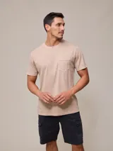 Remera de hombre color beige, de corte recto, manga corta y cuello redondo. Incluye bolsillo en el pecho.