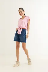 Camisa rosa de viscosa con cuello camisero y mangas cortas. Se anuda en la parte delantera.