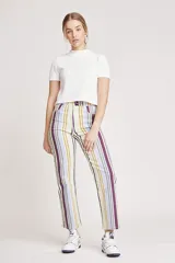 Pantalón jean de corte wide leg con estampado de rayas verticales en tonos lila, verde y amarillo.