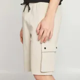 Bermuda color beige con bolsillos tipo cargo con solapa.