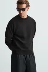 Jersey marrón de punto suave, corte regular, cuello redondo y manga larga con terminaciones en rib.