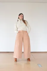 Suéter tejido a mano en 100% lana merino, color crudo, con cuello alto y cierre metálico.