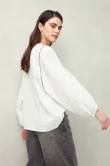 Camisa blanca a rayas grises, de lino, con cuello mao, mangas largas abullonadas y bordados en las sisas.