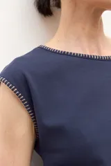 Remera de manga corta color azul marino con cuello redondo y bordado de pespunte en contraste color beige alrededor del cuello y los bordes de las mangas.