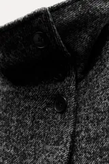 Abrigo corto de hilatura con lana, color gris oscuro jaspeado, con cuello alto, manga larga con trabillas y botones en los puños, bolsillos delanteros y cierre frontal con botones.