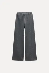 Pantalón gris de tejido de punto canalé, con tiro medio, cintura elástica y pierna ancha.