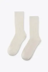 Calcetines largos color crema con textura acanalada.