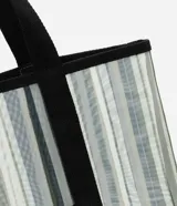 Bolso de playa rectangular de poliéster con rayas verticales en tonos de verde, gris y blanco. Tiene asas de algodón negras y un bolsillo externo.