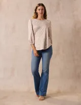 Blusa estampada color beige con cuello redondo calado y mangas 3/4 abullonadas con terminación elastizada.
