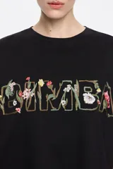 Camiseta blanca de corte boxy con escote redondo, manga corta recta y logo bordado con diseño floral.