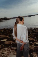 Blusa blanca de algodón bordado con cuello con volados y lazo.