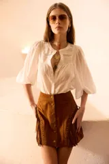 Camisa blanca de voile de algodón con alforzas en el frente, mangas con frunce en los hombros y detalle de puntillas.