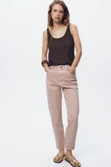 Pantalón de jean gris oscuro, de corte mom fit, tiro alto y largo tobillero. Cuenta con cinco bolsillos, cierre frontal con cremallera y botón.