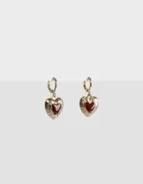Par de aros dorados tipo argolla con dije de corazón esmaltado en rojo y detalle grabado.