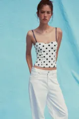 Top blanco con estampado de lunares marrones, corte corsetero, escote corazón y tirantes finos ajustables.