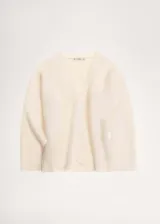 Cardigan color crema de tejido suave con efecto pelo. Tiene escote de pico, cierre frontal con botones y mangas largas.