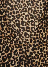 Blusa de tejido fluido color crema con estampado animal print negro, cuello en V y mangas largas abullonadas.