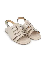 Sandalia chata color crudo con textura croco, hebilla metálica de ajuste en tobillo, forro sintético, plantilla de cuero y suela de TR.